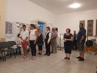 Fiatalok félkörben állnak egy teremben, előttük a házigazdák.