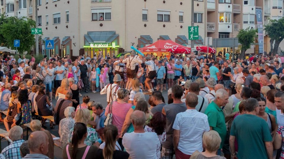 Sváb viseletbe öltözött táncosok lépnek fel a tömeggel körülvett utcán a halfesztiválon