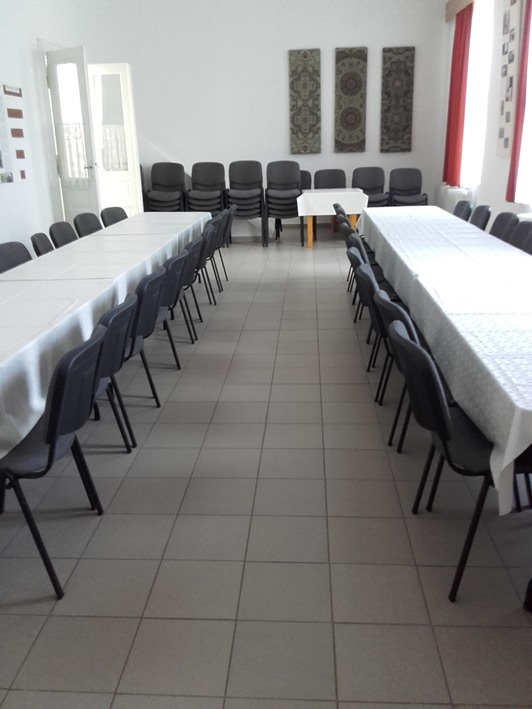 Sorba rakott összecsukható székek a nagyterem fala mellett.