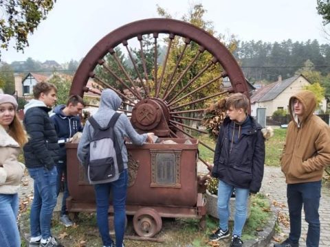 Fiatalok egy régi bányacsille körül a szabadban.