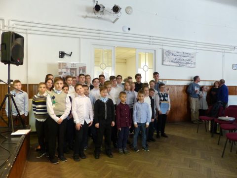 Gyerekek csoportja áll egy teremben a harmonikaversenyen.