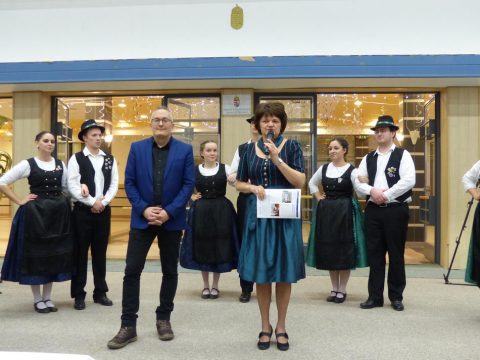 Népviseletes csoport és szónokok a könyvtár bejárata előtt.